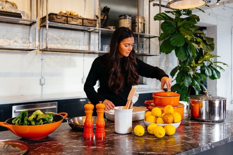 Healthy living, beautiful choices, and everyday essentials at Wealth Health Beauty Shop Woman at kitchen counter assembling healthy ingredients of fruits, vegetables, nutritional supplements from Wealth Health Beauty Shop